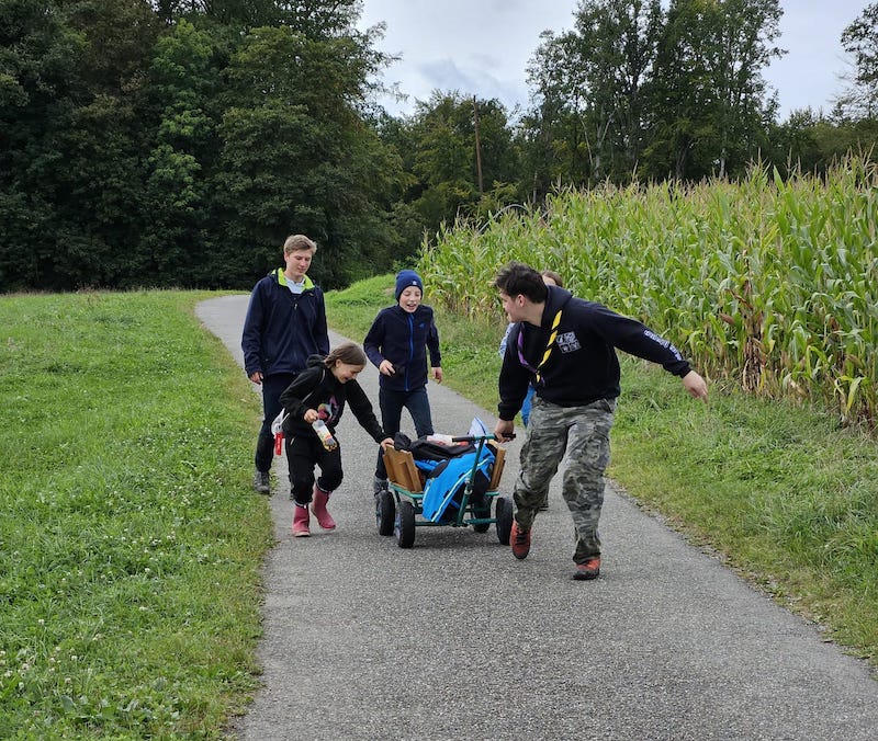 Leitende ziehen einen Bollerwagen einen Weg entlang